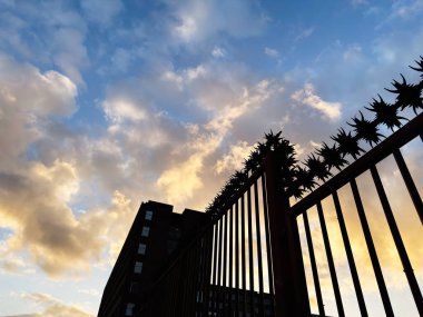 Manchester, İngiltere 'de gün batımında şehir arkaplanı olan sınır çitleri siluetleri.