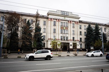 Chisinau, Moldova - 22 Kasım 2025: Chisinau 'da büyük bir neoklasik muhasebe mahkemesi, park edilmiş arabalar ve yayaların yer aldığı şehir manzarası. Curtea de Conturi bir Cumhuriyetçi Moldova