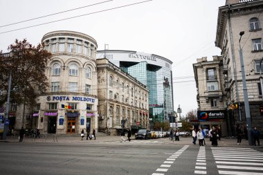 Chisinau, Moldova - 22 Kasım 2025: Cisinau Moldova 'da modern cam bir kulenin yanında tarihi bir postanenin yer aldığı şehir manzarası.