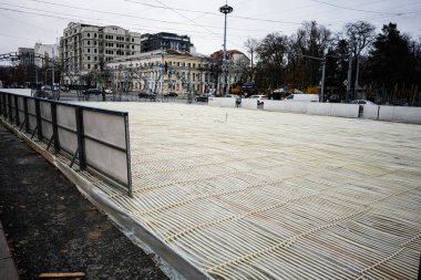 Chisinau, Moldova - 22 Kasım 2025: Chisinau Moldova 'da açık plaza buz pateni pistinin altında zemin döşemeleri ve çevre kent binaları ile birlikte.