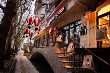 Chisinau, Moldova - 22 Kasım 2025: Cisinau Moldova 'da aydınlık fenerler, merdivenler ve alışveriş çantalarının yer aldığı canlı şehir caddesi.