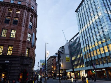 Manchester, İngiltere - 10 Aralık 2025: Manchester 'daki Urban Mount Caddesi, cam ofislerin yanında yayalar ve arabalarla tarihi tuğla mimarisini gösteriyor.