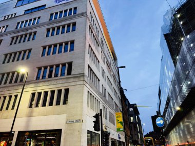 Manchester, İngiltere - 10 Aralık 2025: Manchester 'da uzun binalar, sokak lambaları ve Clarence Caddesi boyunca devam eden inşaatın sergilendiği şehir sahnesi.