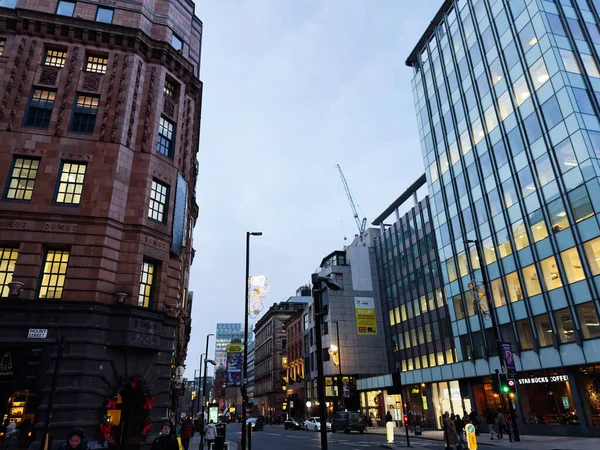 Manchester, İngiltere - 10 Aralık 2025: Manchester 'daki Urban Mount Caddesi, cam ofislerin yanında yayalar ve arabalarla tarihi tuğla mimarisini gösteriyor.