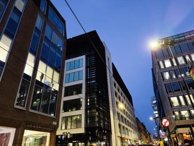 Manchester, İngiltere - 10 Aralık 2025: Günbatımında Manchester Mosley caddesi şehir merkezi aydınlanmış ofisleri ve çağdaş mimarisi ile.