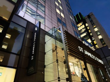 Manchester, İngiltere - 10 Aralık 2025: Camdan duvarları, tabelaları ve sıcak iç ışıkları olan modern Manchester mağazasının dış görünümü.