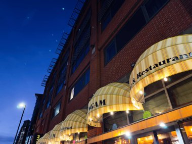 Manchester, İngiltere - 10 Aralık 2025: Manchester Sangam restoran sırasının mavi saatli dış görünüşü.