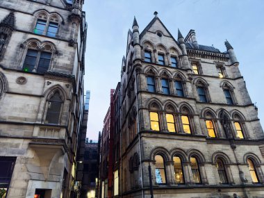 Zarif taş binalar dar bir Manchester caddesinde parıldayan pencereler sıcak, tarihi bir atmosfer yaratır..