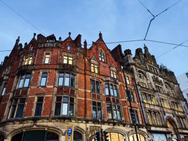 Manchester 'da dekoratif perdeler ve tramvay kabloları olan kırmızı tuğlalı Victoria tarzı binalar.