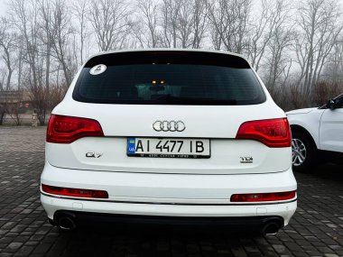 Kyiv, Ukrayna - 19 Aralık 2025: Çakıl taşı parkında beyaz bir Audi Q7 TDI 'nin arka görünüşü.