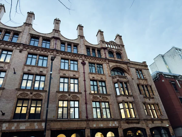 Uzun camlı ve dekoratif detayları olan tarihi Manchester binasının dekoratif tuğla cephesi.