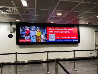 Manchester, İngiltere - 13 Aralık 2025: Manchester, İngiltere 'de çeşitli kadın gruplarıyla cinsiyet güçlendirmeyi destekleyen parlak dijital reklam panosu.