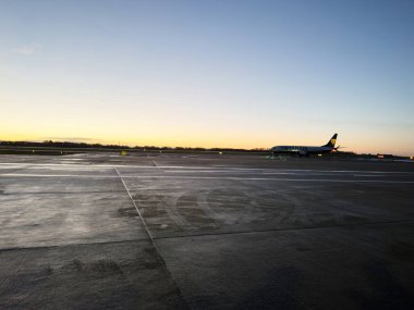 Manchester, İngiltere - 13 Aralık 2025: Manchester pistinde bir Ryanair uçağı kalkışı beklerken gün batımı.