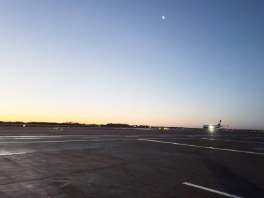 Manchester, İngiltere - 13 Aralık 2025: Manchester Havalimanı 'nda sakin, mavi gökyüzü altında bir uçak taksisi olarak hava karardı.