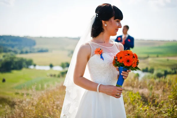 Mariée avec bouquet à la main arrière-plan marié — Photo
