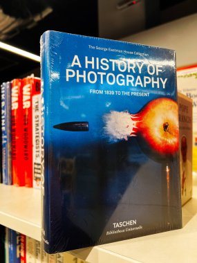 Londra, İngiltere - 12 Aralık 2025: Fotoğraf tarihi üzerine mavi ciltli kitap, kütüphane ortamında renkli başlıklar arasında sergilendi.