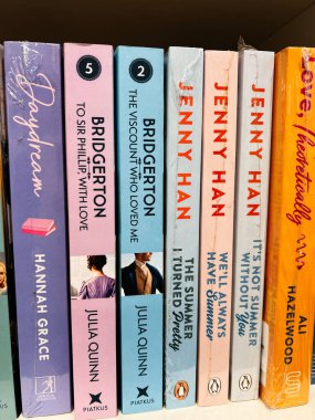 Londra, İngiltere - 12 Aralık 2025: Renkli dikenli ciltli bir dizi ciltsiz aşk romanı koleksiyon yapılabilir kitapçıda.