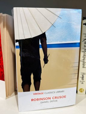Londra, İngiltere - 12 Aralık 2025: Robinson Crusoe 'nun Klasik Klasikler Kütüphanesi baskısı Daniel Defoe tarafından plaj kapağında sergilendi.