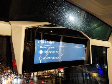 Manchester, İngiltere - 05 Aralık 2025: Manchester otobüsünde yağmurlu bir gece, Mancunian Way ve Sucul Merkezi 'nin sonraki durakları dijital ekran..