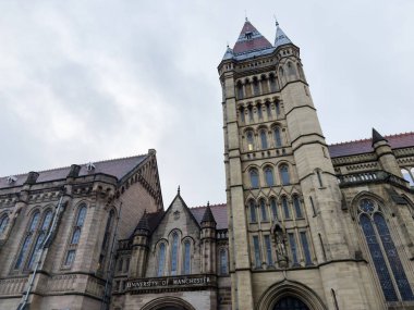 Manchester, İngiltere - 06 Aralık 2025: Manchester Üniversitesi 'nde tarihi ve görkemli kampüs binaları ile etkileyici Gotik kule yükseliyor.