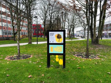 Manchester, İngiltere - Aralık 06, 2025: Manchester 'daki açık hava parkı sahnesinde haritalar ve yenilenebilir iklim mesajları içeren bir bilgi işareti yer alıyor.