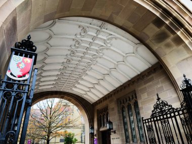 Manchester, İngiltere - Aralık 06, 2025: Büyük kemer ve dekoratif kapı çerçevesi oyulmuş tavan ve taş işçiliğine sahip tarihi Manchester girişi.