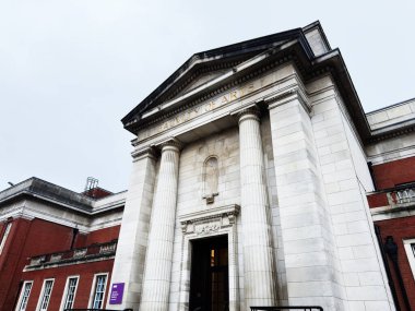Manchester, İngiltere - Aralık 06, 2025: Manchester 'daki etkileyici neoklasik üniversite binası uzun kolonları ve taş cepheleriyle.