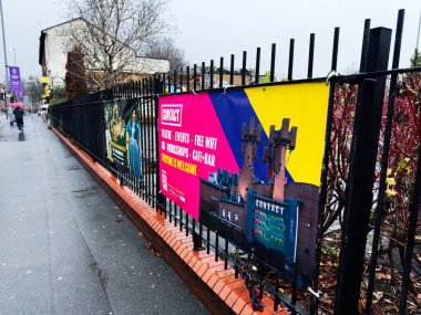 Manchester, İngiltere - Aralık 06, 2025: Manchester 'da bir korkuluk boyunca parlayan pankartlar tiyatro etkinlikleri, kafeler ve bulutlu bir gökyüzü altında ücretsiz kablosuz internet reklamları.