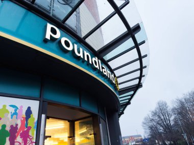 Manchester, İngiltere - Aralık 06, 2025: Manchester, İngiltere 'de poundland mağaza önü, kavisli cam tepe örtüsü ve parlak renkli işaret levhası.