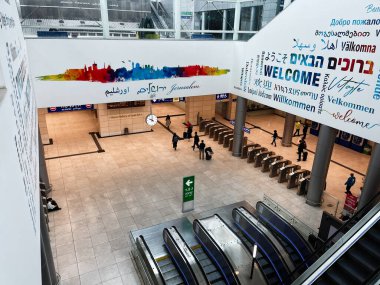 Kudüs, İsrail - 3 Aralık 2022: İsrail Kudüs Yitzhak Navon Tren İstasyonu 'nda yürüyen merdivenlerin yakınındaki çok dilde karşılanan pankartlar ve gezginler.