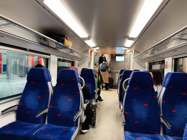 Kudüs, İsrail - 3 Aralık 2022: Parlak bir İsrail treninin içinde, mavi koltuklar ve hareket etmeden önce bavulu olan yolcular. Kudüs Yitzhak Navon Tren İstasyonu