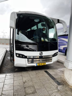 Kudüs, İsrail - 3 Aralık 2022: Modern beyaz bir Volvo vagonu İsrail 'de bir kaldırıma parketmiş ve yolcularla birlikte.