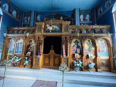 Kudüs, İsrail - 3 Aralık 2022: Kilisede ikonlar, çiçek düzenlemeleri ve mavi dekorların yer aldığı entrika oymalı bir simge ekranı.