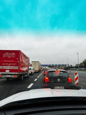 Katowice, Polonya - 29 Kasım 2025: Araçlar ıslak bir otoyolda kamyon ve siyah bir araba yol çalışması ve bariyerlerin yanında bekliyor.