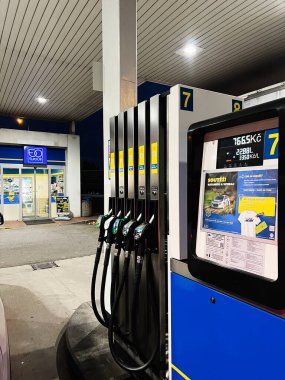 Ostrava, Çek Cumhuriyeti - 29 Kasım 2025: Euro Oil benzin istasyonunda çok sayıda yakıt pompası, poster ve bir bakkal önü gösteren gece sahnesi.