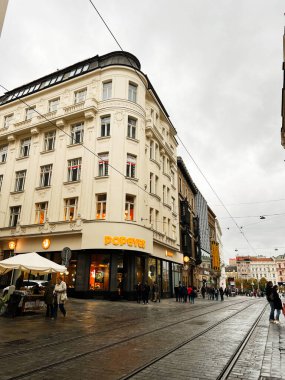 Brno, Çek Cumhuriyeti - 29 Kasım 2025: Kavisli bir köşe bina ve yayalar üzerinde Popeyes mağazası olan kalabalık bir Brno sokak sahnesi.