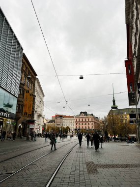 Brno, Çek Cumhuriyeti - 29 Kasım 2025: Yayaların, tramvayların ve klasik mimarinin olduğu kentsel Brno sahnesi.