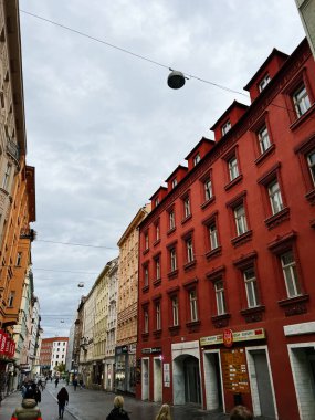 Brno, Çek Cumhuriyeti - 29 Kasım 2025: Renkli sıra evleri, mağazalar ve tabelalar arasında kalabalık bir Avrupa Brno caddesi hizasında.