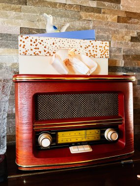 Ostrava, Çek Cumhuriyeti - 29 Kasım 2025: Antika radyo hediye kutuları ve kurdelelerle ahşap bir dolapta oturur ve rahat bir dekoratif sahne yaratır..