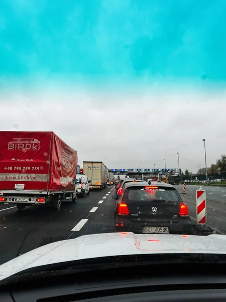 Katowice, Polonya - 29 Kasım 2025: Araçlar ıslak bir otoyolda kamyon ve siyah bir araba yol çalışması ve bariyerlerin yanında bekliyor.