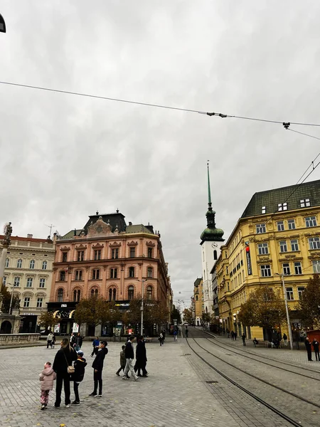 Brno, Çek Cumhuriyeti - 29 Kasım 2025: Renkli tarihi binalar, tramvay rayları ve yürüyen insanlarla dolu bir Brno kasaba meydanı.