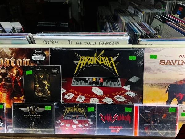 Brno, Çek Cumhuriyeti - 29 Kasım 2025: Meşgul bir plak mağazası raf rafları vinil albümler, canlı kapaklar, ve dağınık oyun kartları bu gece. Arakain Black Jack