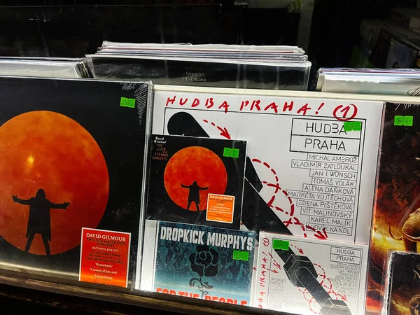 Brno, Çek Cumhuriyeti - 29 Kasım 2025: Kalın turuncu güneş görüntüleri ve kentsel grafik tasarımların yer aldığı bir vinil albüm koleksiyonu. Hudba Praha, Dropkick Murphys, David Gilmour