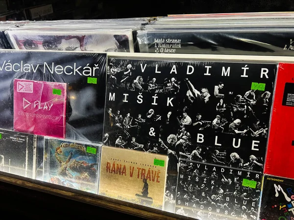 Brno, Çek Cumhuriyeti - 29 Kasım 2025: Bir dükkan vitrininde, Çek müzisyenler ve retro tasarım sergilenen vinil plaklar ve albüm kapakları.