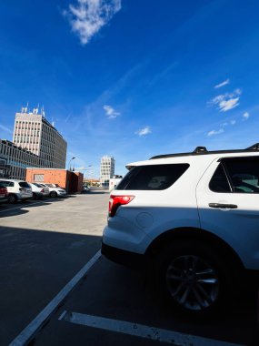 Brno, Çek Cumhuriyeti - 29 Kasım 2025: Beyaz Ford Explorer SUV çatıda park halinde, yüksek binalar mavi gökyüzü altında.