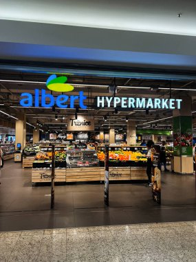 Brno, Çek Cumhuriyeti - 29 Kasım 2025: Albert modern hipermarketinde, müşteriler iyi ışıklandırılmış, organize edilmiş vitrinlerde meyve, sebze ve kilerlere göz gezdiriyorlar.