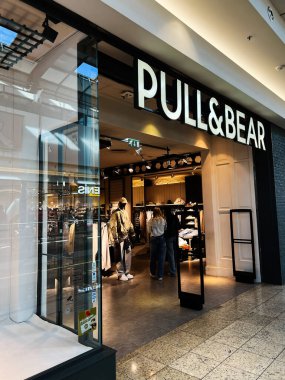 Brno, Çek Cumhuriyeti - 29 Kasım 2025: Alışveriş yapanların giysi ve giysi raflarında gezindiği bir alışveriş merkezindeki Bear mağazasını çekin.