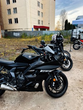 Ternopil,Ukraine - November 29, 2025: Sleek black Yamaha YZF-R7 sport bike in a gravel lot with additional bikes and an urban building backdrop.