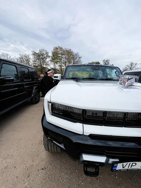 Ternopil, Ukrayna - 29 Kasım 2025: Beyaz pikap GMC Hummer EV yakınındaki çakıllı bir otoparkta üstü açılabilir araç ve kaputta QR kod kartı.