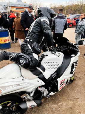 Ternopil, Ukrayna - 29 Kasım 2025: Beyaz spor Suzuki Hayabusa motosikletli bir bisikletçi açık hava etkinliğinde izleyiciler arasında.